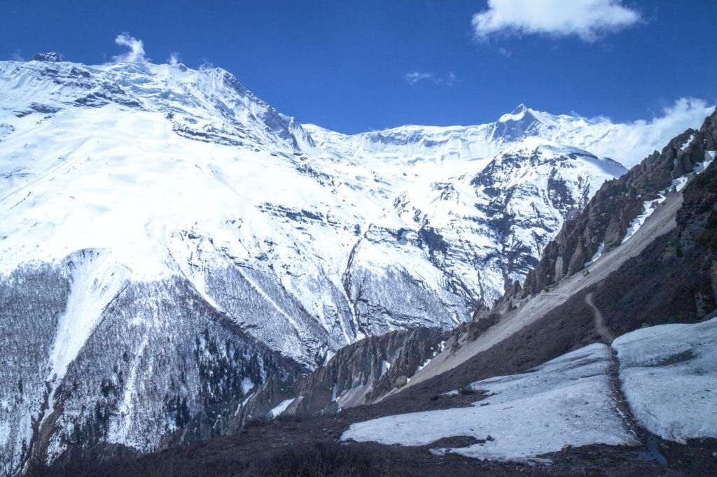 03_Majestic_snow_capped_mountains_under_a_clear_blue_sky_in_Manang_Nepal_
