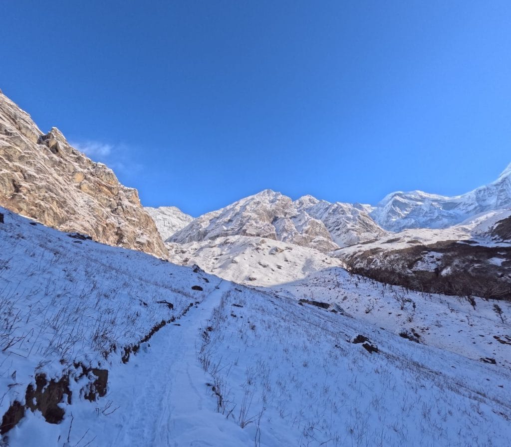 03_Scenic_view_of_a_snow_covered_path_leading_to_majestic_mountains_in_By